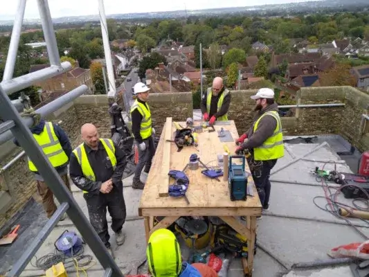 Building team working on the tower roof lead